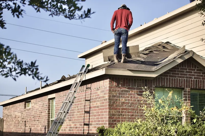 Professional roofer working on a residential roof in Quincy Point